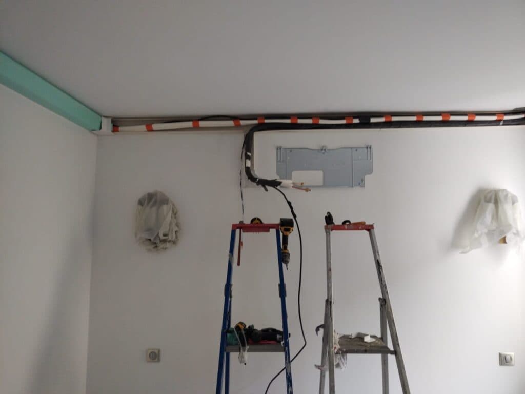 Pose d'un split mural : support fixé et liaisons frigorifiques en goulotte